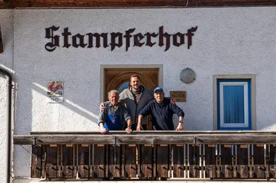 a group of three people standing on a balcony at Stampferhof - Agriturismo in Racines