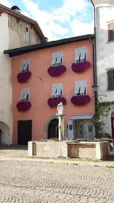 a pink building with windows and flowers on it at mama's room in Egna
