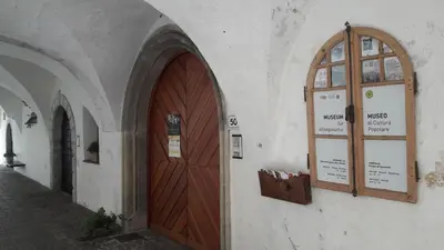 a building with a wooden door and two windows at mama's room in Egna