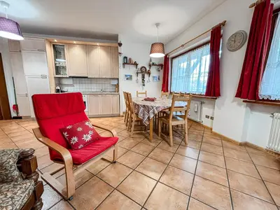 a kitchen and dining room with a table and chairs at Appartamento Al Ruscello in Canazei