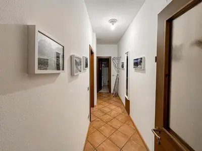a hallway with pictures on the walls of a room at Appartamento Al Ruscello in Canazei