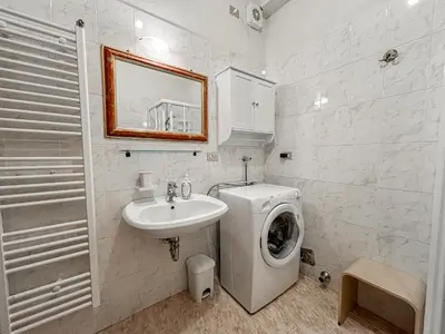 a bathroom with a washing machine and a sink at Appartamento Al Ruscello in Canazei