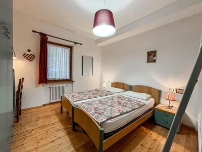 a bedroom with a bed in a room at Appartamento Al Ruscello in Canazei