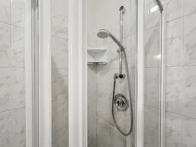 a shower with a glass door in a bathroom at Appartamento Al Ruscello in Canazei