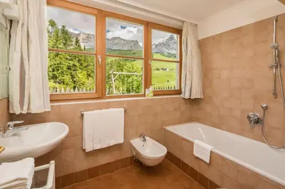 a kitchen and living room with a table and a dining room at Appartamenti Les Viles in La Villa