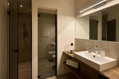 a bathroom with a white sink and a shower at Chalet La Varieté in La Villa