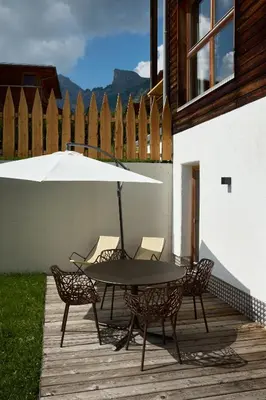 a patio with a table and chairs and an umbrella at Chalet La Varieté in La Villa