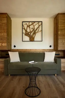 a living room with a green couch and a table at Chalet La Varieté in La Villa