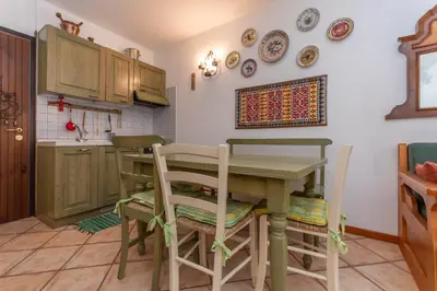 a kitchen with a table and some plates on the wall at Appartamento Boè Arabba in Livinallongo del Col di Lana