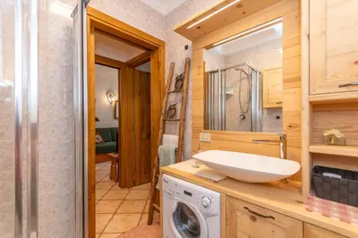 a bathroom with a sink and a washing machine at Appartamento Boè Arabba in Livinallongo del Col di Lana