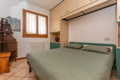 a bedroom with a large bed in a room at Appartamento Boè Arabba in Livinallongo del Col di Lana
