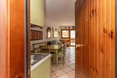 a kitchen with a sink and a table with a dining room at Appartamento Boè Arabba in Livinallongo del Col di Lana