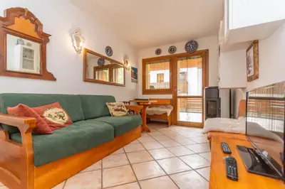 a living room with a green couch and a table at Appartamento Boè Arabba in Livinallongo del Col di Lana