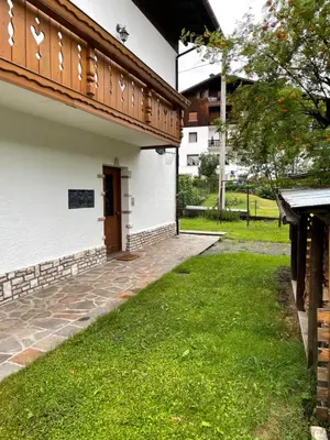 a door on the side of a building with green grass at Appartamento Canes in Falcade