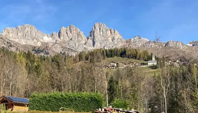 a mountain range with a house in front of it at Appartamento Canes in Falcade
