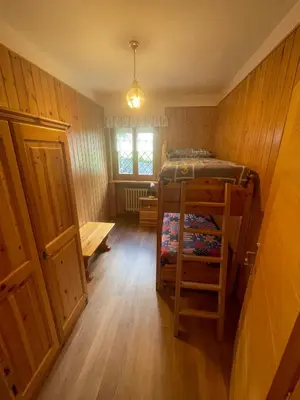 a small room with a bunk bed and a window at Appartamento Canes in Falcade
