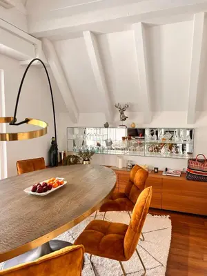 a kitchen with a wooden table and chairs at Penthousetraum im Herzen Merans in Merano