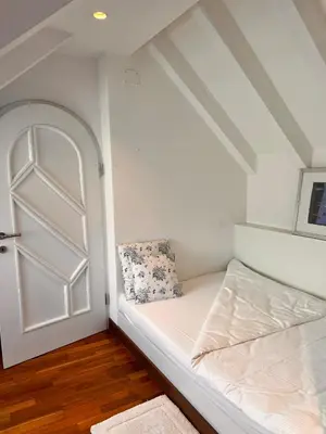 a small room with a bed and a door at Penthousetraum im Herzen Merans in Merano