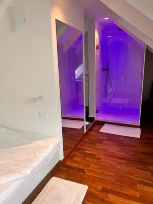 a room with a purple room with a bed and a mirror at Penthousetraum im Herzen Merans in Merano
