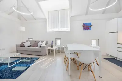 a white living room with a table and a couch at Sweethome Gries - Con Garage in Bolzano
