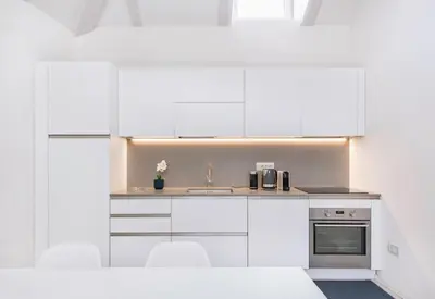 a kitchen with white cabinets and a sink at Sweethome Gries - Con Garage in Bolzano