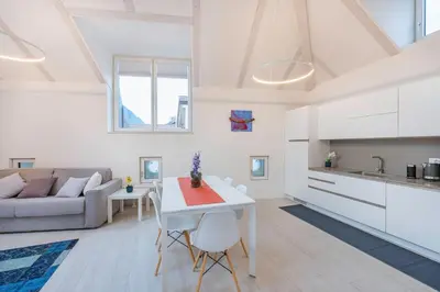 a kitchen and living room with a table and a couch at Sweethome Gries - Con Garage in Bolzano