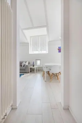 a living room with white walls and a white floor at Sweethome Gries - Con Garage in Bolzano