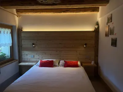 a bedroom with a bed with two red pillows at Locanda al Toal in Moena