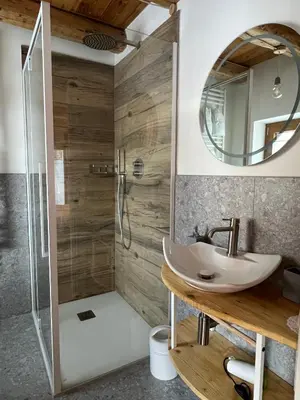 a bathroom with a sink and a shower with a mirror at Locanda al Toal in Moena
