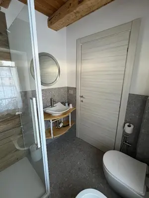 a bathroom with a toilet and a sink at Locanda al Toal in Moena