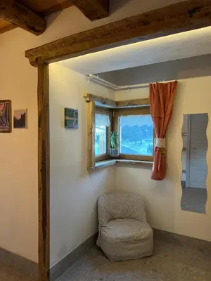 a chair in a room with a window at Locanda al Toal in Moena
