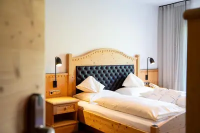 a bedroom with a large bed with white pillows at Sonus Alpis - Adults Only in Castelrotto