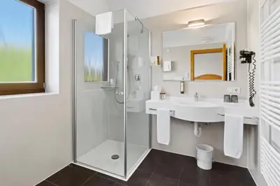 a bathroom with a glass shower and a sink at Sonus Alpis - Adults Only in Castelrotto