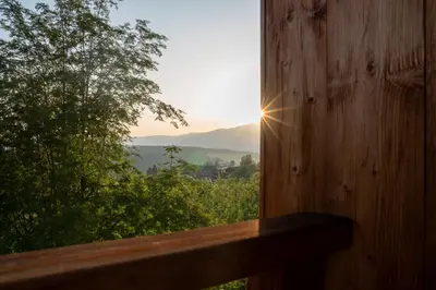 a view of the sun setting through a window at Sonus Alpis - Adults Only in Castelrotto