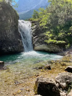 a waterfall on the side of a mountain next to a river at Mezzodi in Mareson