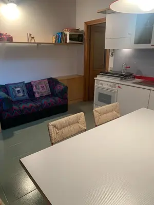 a kitchen and living room with a table and a couch at Mezzodi in Mareson
