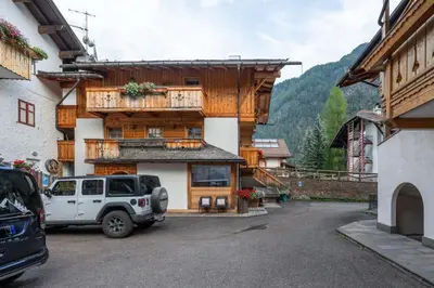 a car parked in a parking lot in front of a building at Cesa Rosy in Campitello di Fassa
