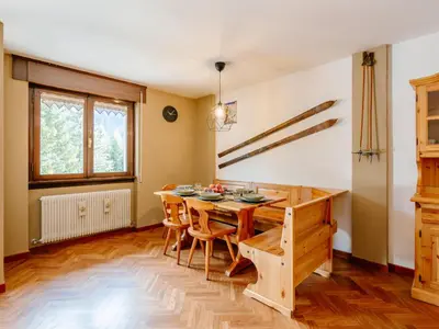 a living room with a wooden table and a dining room at Apartment Enrosadira-11 by Interhome in Alba di Canazei