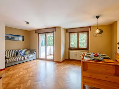 a living room with a couch and a sliding glass door at Apartment Enrosadira-11 by Interhome in Alba di Canazei