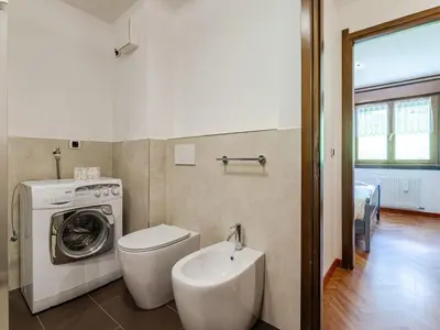 a bedroom with two beds and a dresser and a mirror at Apartment Enrosadira-11 by Interhome in Alba di Canazei