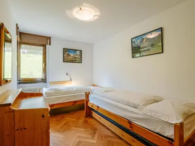 a bedroom with two beds and a window at Apartment Enrosadira-11 by Interhome in Alba di Canazei