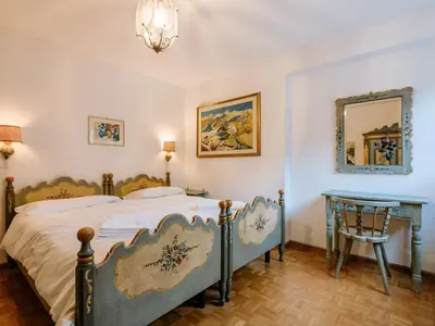 a bedroom with a bed and a table at Apartment Luisa by Interhome in Canazei