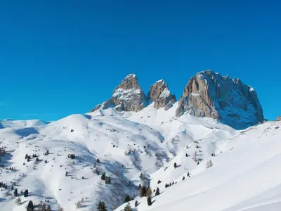 a mountain covered in snow with a blue sky at Apartment Luisa by Interhome in Canazei