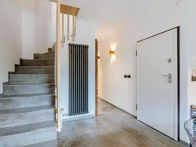 a staircase in a home with white walls and concrete floors at Apartment Family House by Interhome in Moena