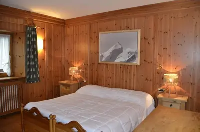 a bedroom with a bed and two night stands with lamps at Apartment with three bedrooms and garden in Chiave in Chiave
