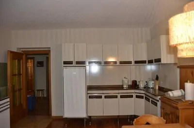 a kitchen with white cabinets and a stainless steel refrigerator at Apartment with three bedrooms and garden in Chiave in Chiave