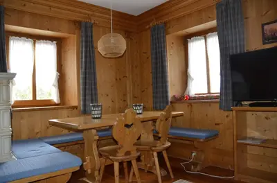 a dining room with a table and chairs and a television at Apartment with three bedrooms and garden in Chiave in Chiave
