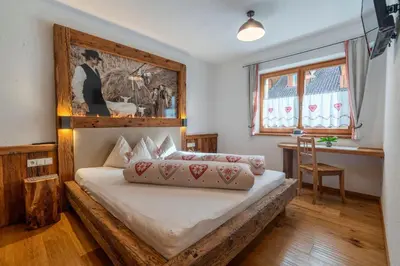a bedroom with a bed with a wooden headboard at Weliserhof in Brunico