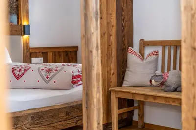 a wooden bunk bed with a bench and pillows at Weliserhof in Brunico