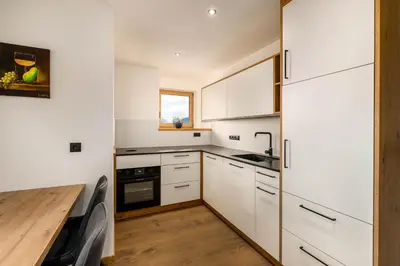 a small bedroom with a bed and a wooden cabinet at Appartment Über die Wolken in Maranza